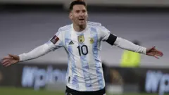 Lionel Messi celebrates with his arms stretched out wide