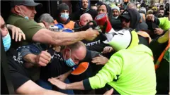 Construction workers clash with industry union members at a protest at Construction, Forestry, Maritime, Mining and Energy Union (CFMEU) headquarters in Melbourne