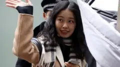 Zhou Xiaoxuan, also known by her online name Xianzi, waves as she enters a court for a sexual harassment case involving a Chinese state TV host, in Beijing, China December 2, 2020.