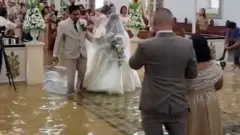 عروس تأبى تأجيل زفافها وتسير في ممر غمرته المياه بعد الإعصار