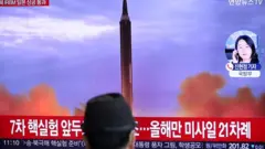 Man in front of public TV screen