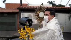 Padre em procissão de máscara