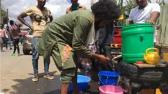 አዲስ አበባ-እጁን የሚታጠብ መንገደኛ