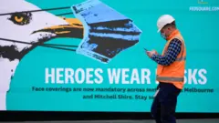 Un hombre frente a un cartel en Melbourne
