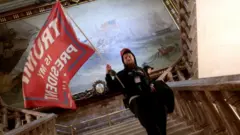 Un amotinado dentro del Capitolio de Estados Unidos ondea una bandera que dice "Trump es mi presidente" el pasado 6 de enero de 2021.