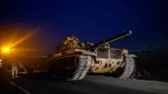 A Turkish tank drives towards the border with Syria near Akcakale