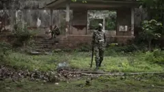 Deux soldats centrafricains, en treillis, près d'un bâtiment abandonné