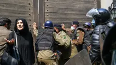 इमरान खानको घरको गेट खोल्न खोज्दै प्रहरी