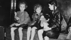 Black and white picture of three girls sitting on a bench