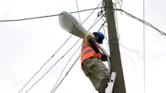 Electricity worker ontop pole