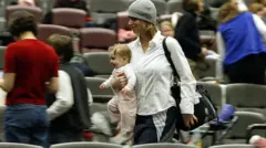 žena u naručju nosi bebu, hoda između sedišta u bioskopu 