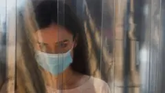 امرأة ترتدي كمامة