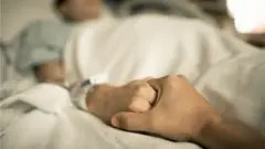 Homem segurando mão de mulher doente