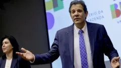 Fernando Haddad com mãos abertas e expressãojogos de pc onlinequestionamento; ao fundo, Simone Tebet