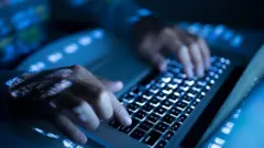 A person typing on a laptop computer