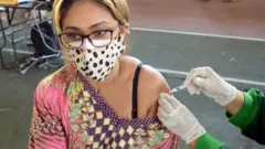 ইন্দোনেশিয়ার বালিতে টিকা নিচ্ছেন এক নারী। প্রধানত চীনের তৈরি সিনোভ্যাক টিকা দেওয়া হচ্ছে সেদেশে
