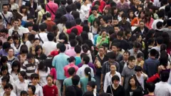Pedestrians cross a busy intersection in the Xidan shopping area, Beijing.