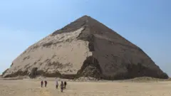 People walk in front of the Bent Pyramid. Photo: 13 July 2019