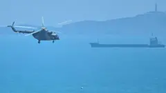 Chinese military helicopters fly past Pingtan island, one of mainland China's closest point from Taiwan, in Fujian province on August 4, 2022, ahead of massive military drills off Taiwan following US House Speaker Nancy Pelosi's visit to the self-ruled island.
