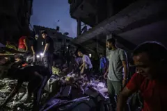 Des équipes de défense civile et des civils mènent une opération de recherche et de sauvetage sous les décombres des bâtiments démolis après une attaque israélienne sur une résidence familiale à Khan Yunis, Gaza, le 13 novembre 2023.