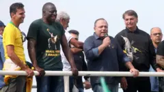 Pazuello fala no microfone em cima de carro de som, ao lado de Bolsonaro e outros homens, todos sem máscara