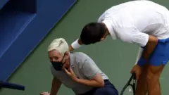 Novak Djokovic checks on the line judge after hitting her with a ball