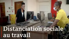 Deux femmes tentant de pousser leurs bureaux. (Mila Kimbuini Minta