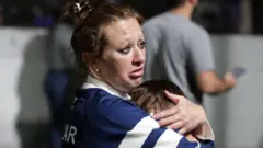 Fans of Gimnasia y Esgrima La Plata react in the field of play after being affected by tear gas