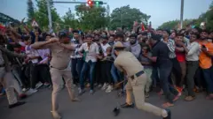 गर्दीवर लाठीचार्ज करणारे पोलीस