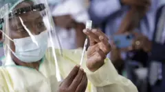 Un fonctionnaire de la santé prélève un échantillon sur une personne le premier jour de la vaccination contre le Covid-19, à l'hôpital Wilkins de Harare, au Zimbabwe, le 18 février 2021.