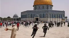 متظاهرون فلسطينيون يشتبكون مع قوات الشرطة الإسرائيلية في باحات المسجد الأقصى عقب صلاة الجمعة