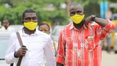 Des personnes portant un masque en tissus