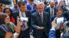 Спикер Кевин Маккарти (на фото в центре) после голосования о приостановке потолка долга США