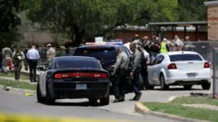 Carros e policiais em volta de escola