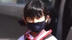 కరోనా మాస్కుతో చిన్నారి