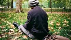 Sunny relaxes in St James's Park, with his tote bag behind him