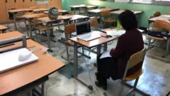 韓國的一名教師在學校裏通過手提電腦與學生連線溝通。