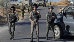 جنود إسرائيليون يقفون في مكان العثور على جثة الجندي