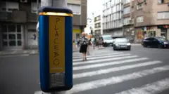 Taster na semaforu na prometnoj beogradskoj ulici, na njemu je crnim markerom napisano - PLACEBO