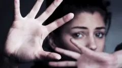 Woman shielding her face with her hands
