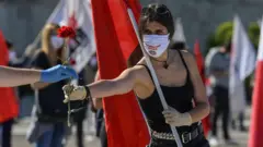 A woman hands out red carnations