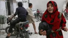 A girl cries following an air strike on the Syrian opposition-held town of Kfar Ruma, Idlib province, 30 May 2019