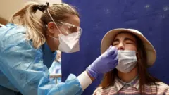 A medical worker takes nasal swab samples at a test station for Covid-19 coronavirus in Montpellier, France, 13 October 2020