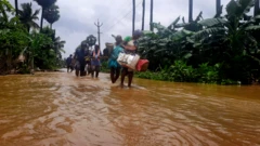 వరద నీటిలో సురక్షిత ప్రాంతాలకు తరలి వెళుతున్న ప్రజలు