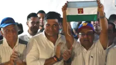 El candidato opositor a la gobernación de Barinas, Sergio Garrido, celebrando con una bandera del estado.