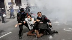 ضباط شرطة مكافحة الشغب يعتقلون متظاهرين أثناء محاولتهم تحدي الحظر والتقدم في مسيرة إلى ساحة تقسيم