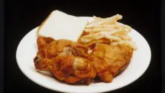 A meal featuring french fries, fried chicken and white bread