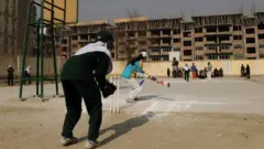 Afghan girls play cricket on the school grounds in Kabul on December 28, 2010