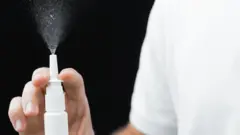 Un médecin montre le fonctionnement d'un nébuliseur nasal