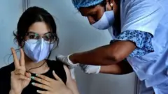 தடுப்பூசி செலுத்திக் கொள்ளும் பெண்